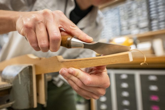 Close-up of someone using a chisel on a piece of wood