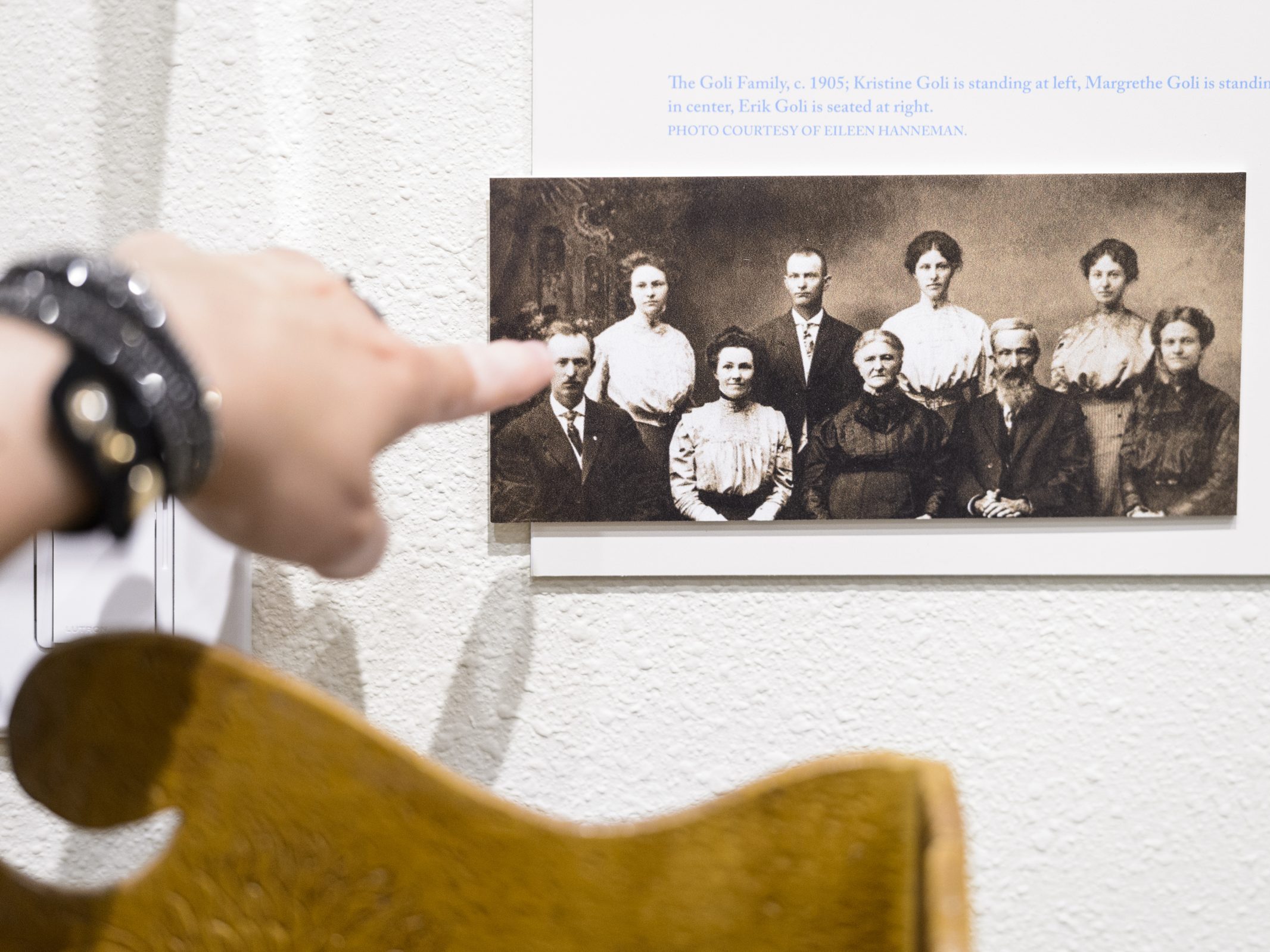 Someone pointing at a photo with a family from a very long time ago.