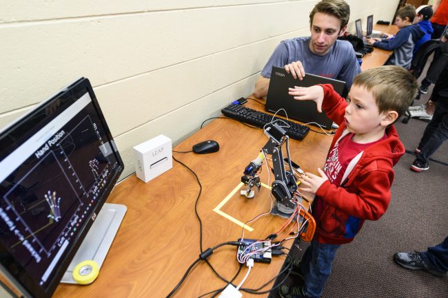 A young boy learning about mechanics and robotics.