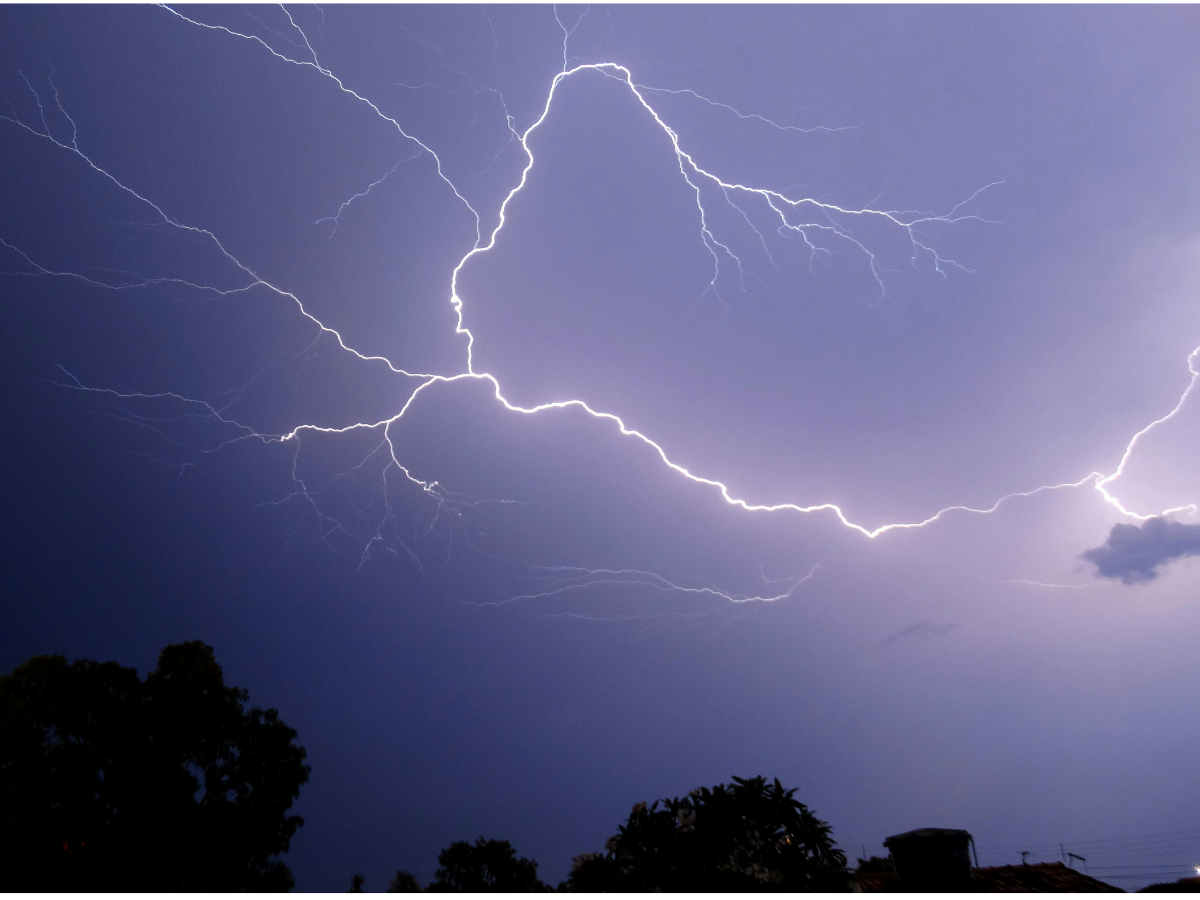 Stormy purple sky with lightning streaking through.